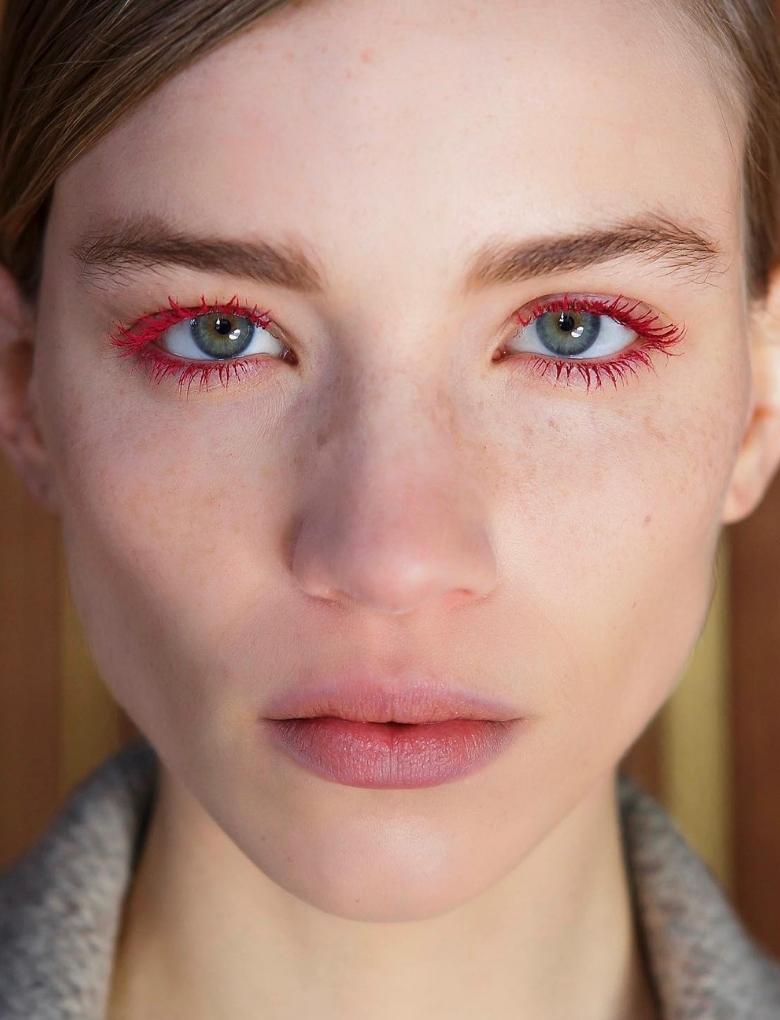 model with blue eyes wearing red mascara