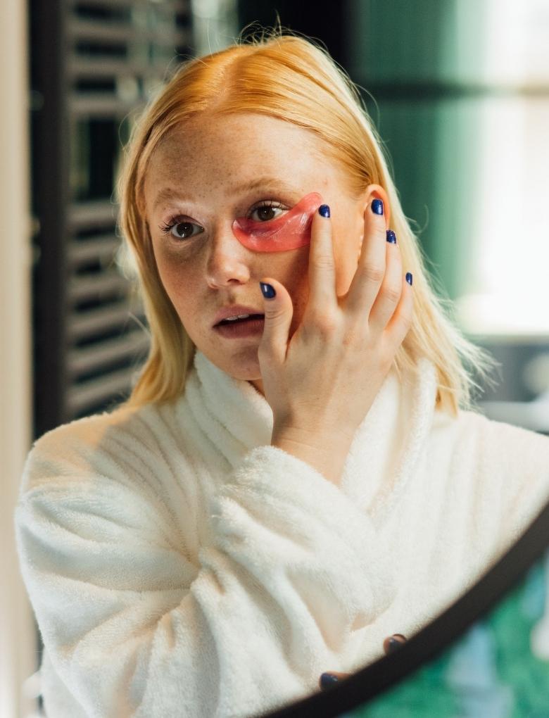 woman applying an eye mask